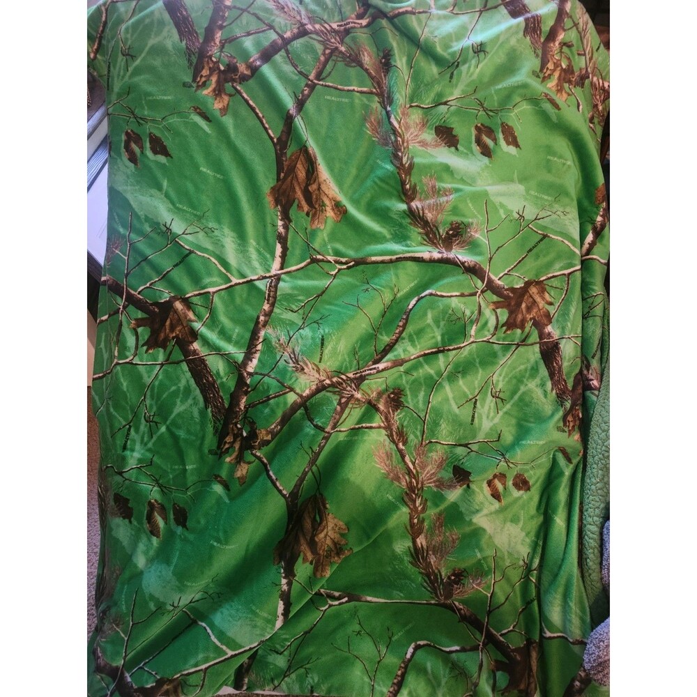 Realtree brand camouflage comforter or blanket featuring a green forest pattern.